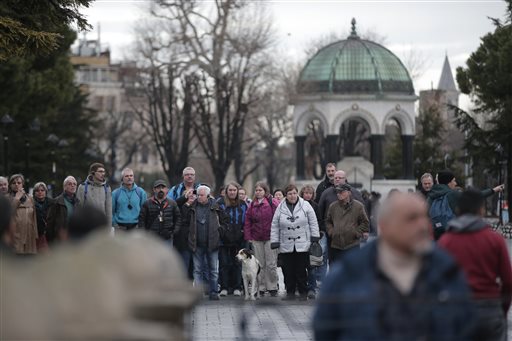 Tourists walk at the site of Tuesday's explosion in the historic Sultanahmet district in Istanbul Wednesday Jan. 13 2016. A suicide bomber detonated a bomb in the heart of Istanbul's historic district on Tuesday morning killing 10 foreigners