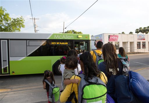 2015 immigrant families many of them mothers with children board a bus headed to the downtown bus station in McAllen Texas. The immigrants mostly from Central America had crossed the Rio Grande and were later