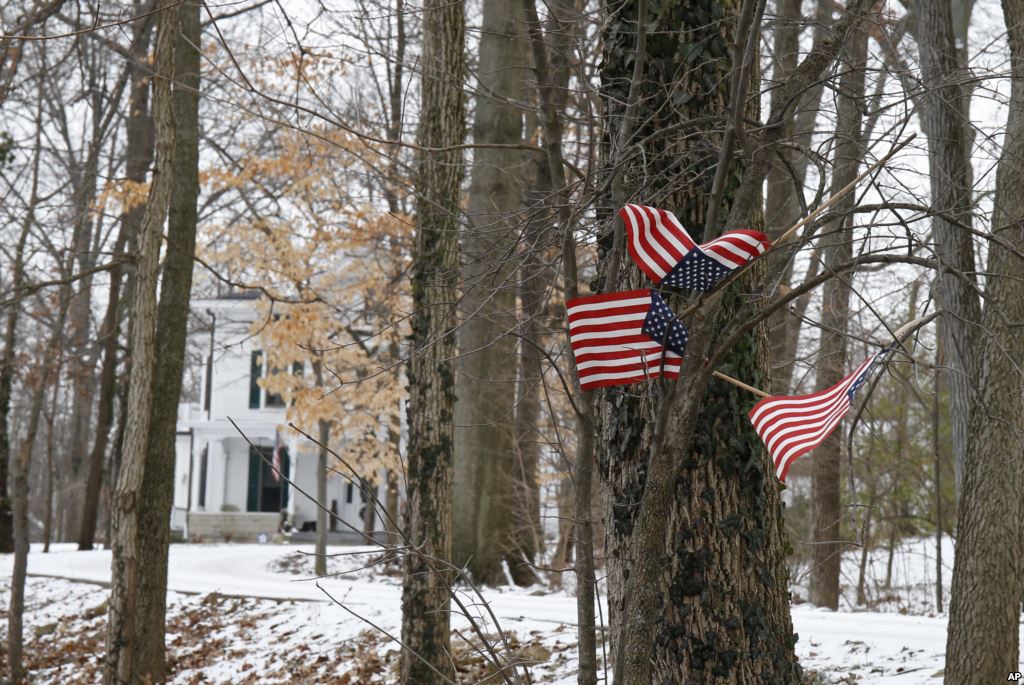 Small American flags have been placed in the trees in front of the Warmbier family home Friday Jan. 22 2016 in Wyoming Ohio. North Korea on Friday announced the arrest of Otto Warmbier a university student from Ohio for what it called a'hostile