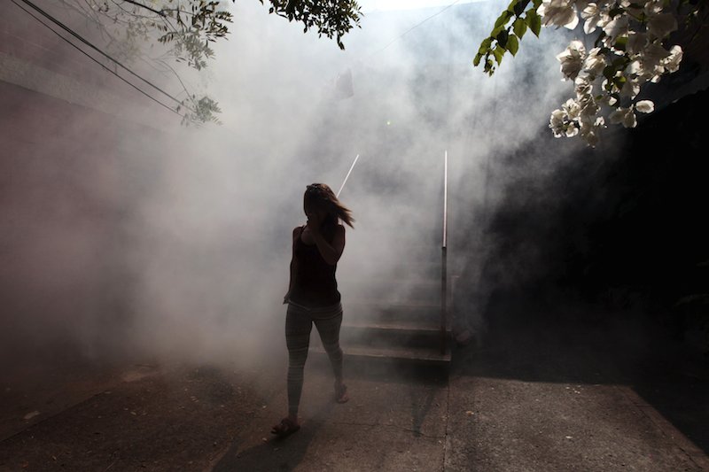 A woman leaves her apartment as health workers fumigates her neighbourhood as part of preventive measures against the Zika virus and other mosquito-borne diseases in Soyapango El Salvador