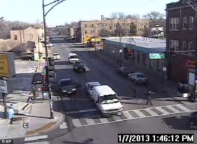 A Chicago police officer lower right corner of the frame is seen aiming his gun at Cedrick Chatman who is not