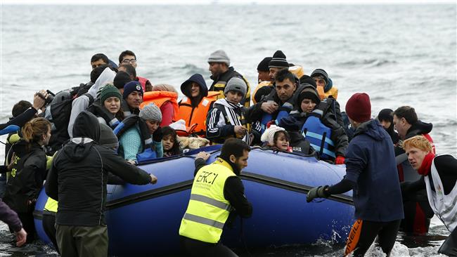 Volunteers pull a raft packed with refugees as they arrive on a beach on the Greek island of Lesbos