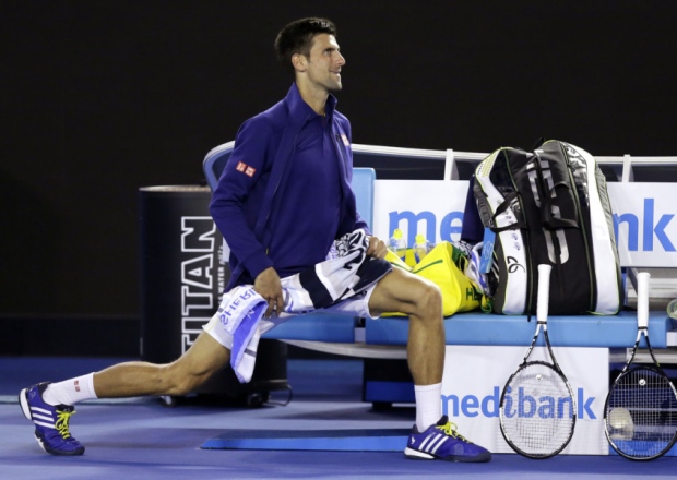 WE CAN WORK IT OUT Novak Djokovic of Serbia stretches while he waits for his opponent Kei Nishikori to return to the court