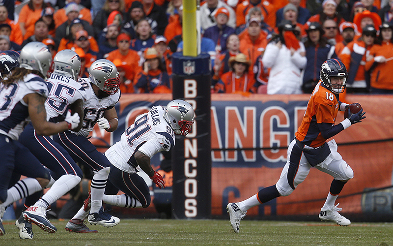 Denver Broncos quarterback Peyton Manning is chased out of the pocket by New England Patriots defenders during the first half the NFL football AFC Championship game between the Denver Broncos and the New England Patriots Sunday Jan. 24 2016 in Denver