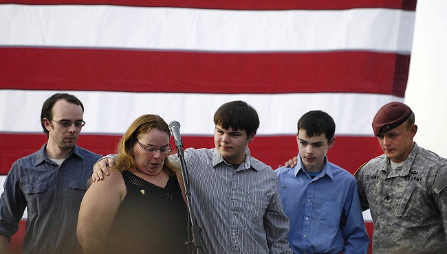 The family of the slain officer react on stage during a vigil at Lakefront Park to honor Lt. Charles Joseph Gliniewicz Wednesday Sept. 2 2015 in Fox Lake Ill. Gliniewicz was shot and killed Tuesday while pursuing a group of suspicious men. Authoriti