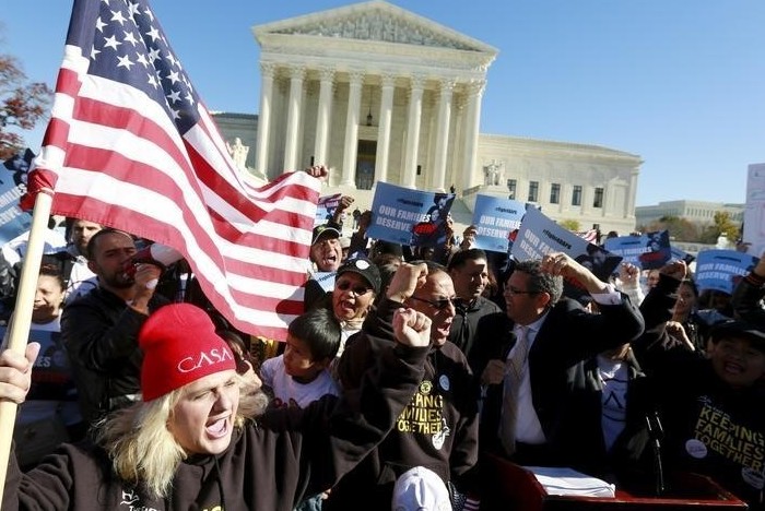 Immigrants and community leaders rally in front of the U.S. Supreme Court to mark the one-year anniversary of President Barack Obama's executive orders on immigration in Washington