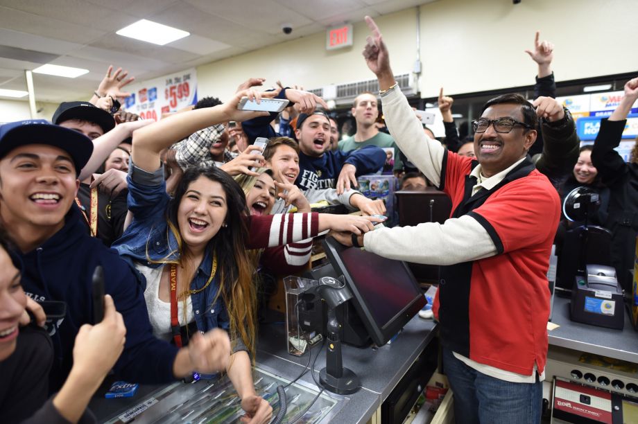 7-Eleven store clerk M. Faroqui celebrates with customers after learning the store sold a winning Powerball ticket on Wednesday Jan. 13 2016 in Chino Hills Calif. One winning ticket was sold at the store located in suburban Los Angeles said Alex Trave