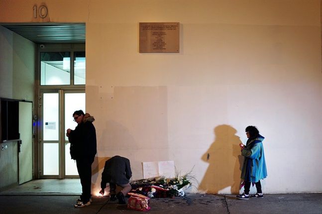 People light candles outside satirical newspaper Charlie Hebdo former office in Paris Wednesday Jan. 6 2016. France this week commemorates the victims of last year's Islamic extremist attacks on satirical weekly Charlie Hebdo and a Jewish supermarket