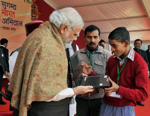 Prime Minister Narendra Modi interacting with a'Divyang  child at a function in Varanasi on Friday.- PTI