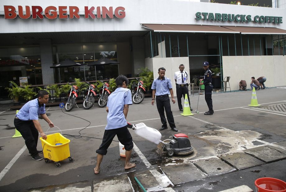 Workers clean up the area where Islamic militants mounted an attack Thursday in Jakarta