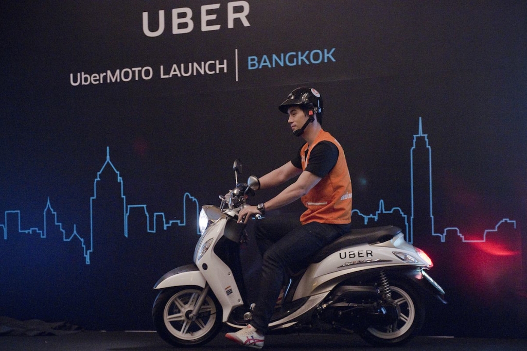 A man drives a motorbike onto a stage during the launch of UberMOTO at a hotel in Bangkok. – AFP pic