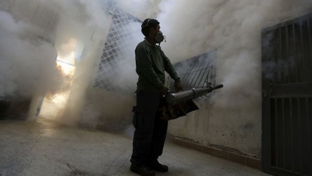 A municipal worker fumigates inside a building to help control the spread of the mosquito-borne Zika virus in Caracas