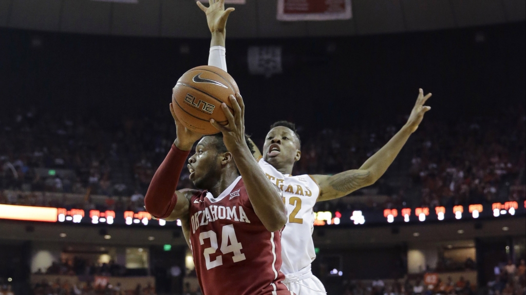 Oklahoma guard Buddy Hield drives around Texas guard Kerwin Roach Jr. during the first half of an NCAA college basketball game Saturday Feb. 27 2016 in Austin Texas