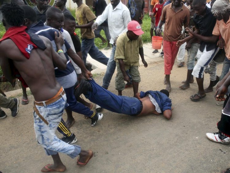 Protesters drag a female police officer accused of shooting a protestor in the Buterere neighbourhood of Bujumbura Burundi