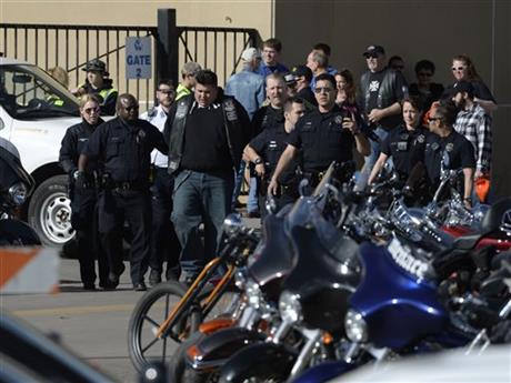 Denver Police escort a man in handcuffs away from the National Western Complex Saturday Jan. 30 2016 in Denver. Denver police say multiple people were injured in a deadly stabbing and shooting at The Colorado Motorcycle Expo. (Andy Cross  The Denver Po