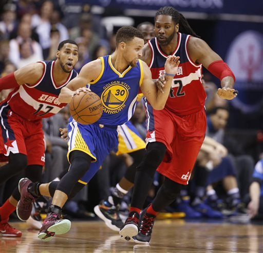 Golden State Warriors guard Stephen Curry moves away from Washington Wizards guard Garrett Temple and center Nene, from Brazil during the first half of an NBA basketball game Wednesday Feb. 3 2016 in Washington