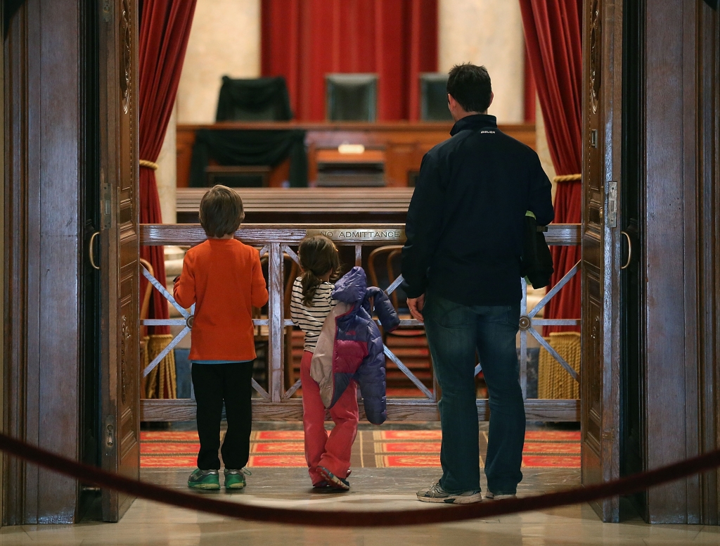 WASHINGTON DC- FEBRUARY 17 Tourists Eric Annes, stands with his daughter Nala, and son Kaelen as they look into the chamber of the US Supreme Court where a black wool crepe cloth covers the bench and seat where the late Justice Antonin Scalia