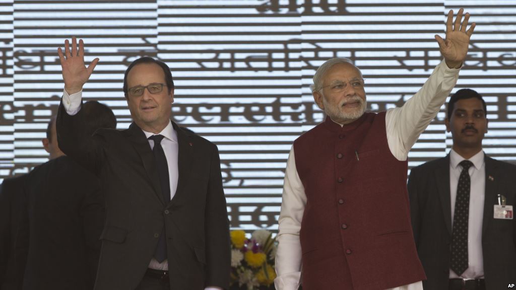 French President Francois Hollande left and Indian Prime Minister Narendra Modi wave at the audience as they arrive for the foundation stone laying for the headquarters of the International Solar Allliance at Gurgaon outskirts of New Delhi Jan. 25 20