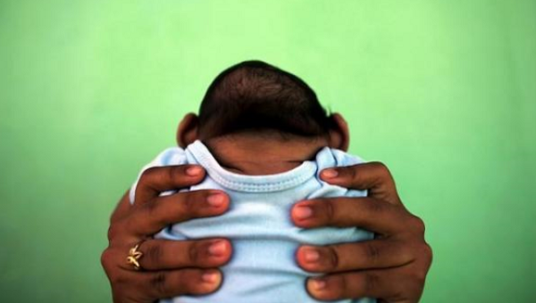 Jackeline 26 holds her son who is 4-months old and born with microcephaly in front of their house in Olinda near Recife Brazil Feb. 11 2016