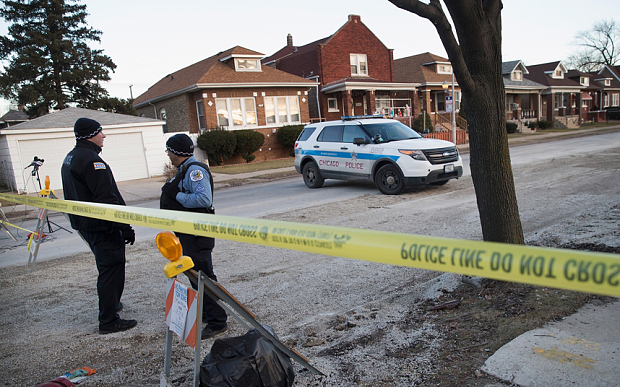 Chicago police guard the perimeter of a crime scene where six people were found slain on the city's Southwest Side