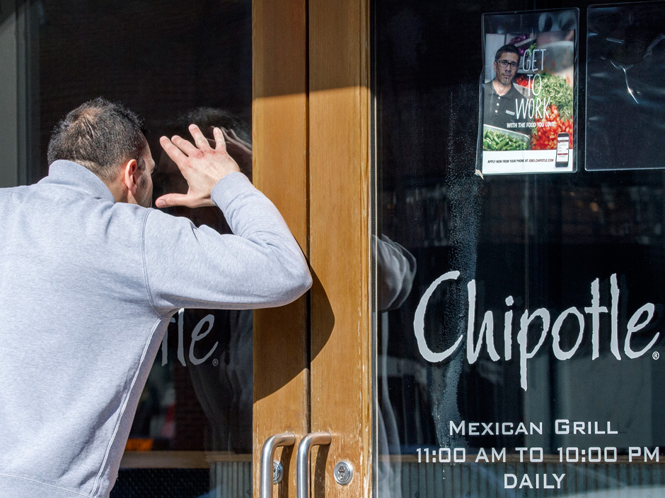 A man looking to eat lunch looks through the locked front door of a Chipotle restaurant on Monday. Chipotle restaurants across the U.S. are temporarily closing until 3pm EST in an effort to educate 60,000 employees about the food-borne illnesses that hav