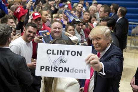 Republican presidential candidate Donald Trump pauses with a sign with his autograph on it while greeting his supporters at a rally Sunday Jan. 31 2016 in Council Bluffs Iowa