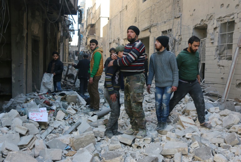 AFP  File  Thaer MohammedA Syrian man comforts a boy amid the rubble of buildings following a reported air strike on the rebel-held neighbourhood of al Kalasa in Aleppo