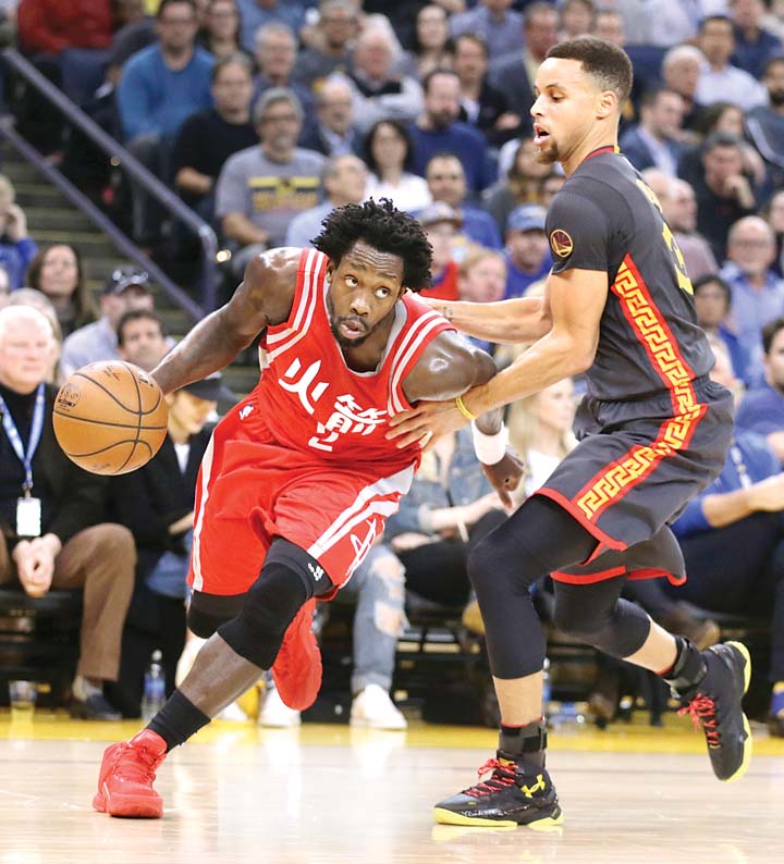 Golden State Warriors’ Stephen Curry defends Houston Rockets’ Patrick Beverley during their NBA game Tuesday in Oakland. The Warriors prevailed 123-110 to extend their home winning streak to 42 games