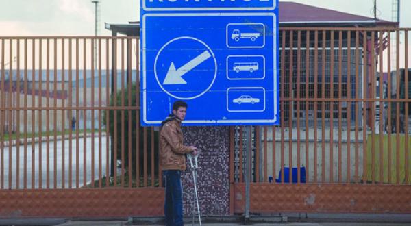 A Syrian who escaped bombing in Aleppo and its surroundings stands in front of the “Door of Safety” border gate waiting for the Turkish authorities to allow him to cross