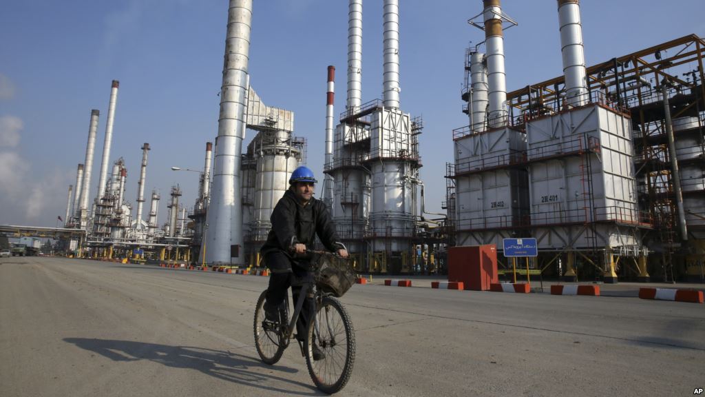 FILE- Iranian oil worker rides his bicycle at the Tehran's oil refinery south of the capital Tehran Iran