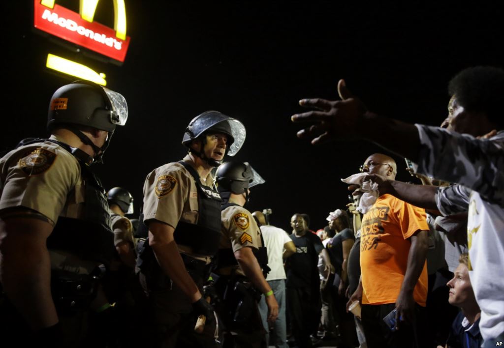 FILE- Officers and protesters face off along West Florissant Avenue in Ferguson Mo. Aug. 10 2015