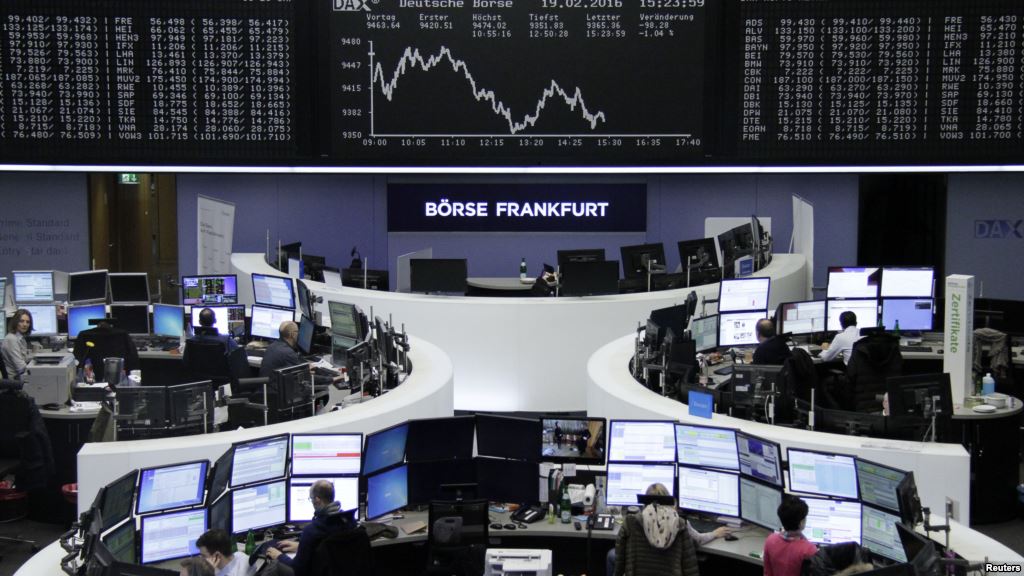 FILE- Traders work at their desks in front of the German share price index DAX board at the stock exchange in Frankfurt Germany Feb. 19 2016