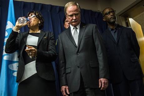 Flint Mayor Karen Weaver drinks from a bottle of water beside Michigan Department of Environmental Quality Director Keith Creagh as Gov. Rick Snyder fields questions from reporters about the Flint water crisis during a press conference on Wednesday Jan