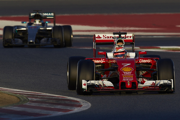 F1 driver Kimi Raikkonen of Finland drives his new Ferrari ahead of Lewis Hamilton of Britain driving a Mercedes during a testing session at the the Cataluny