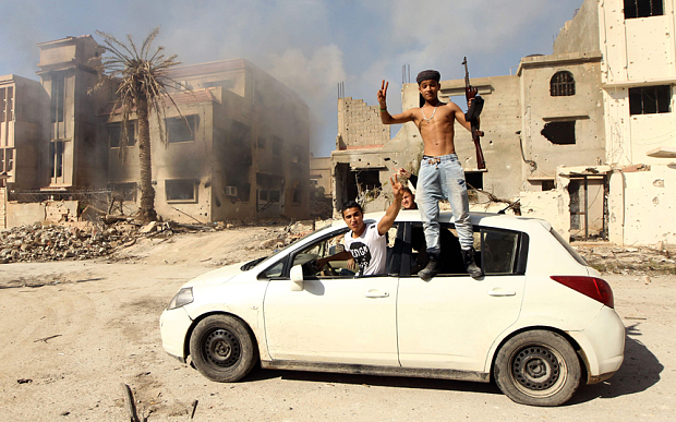 Fighters loyal to Libya's internationally recognised government celebrate as they come close to seizing Benghazi yesterday