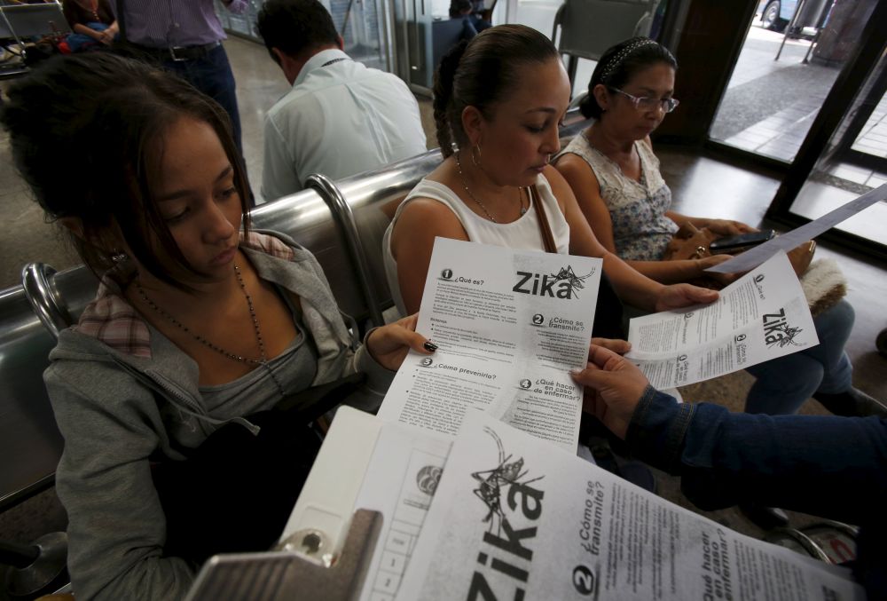 Information on preventing the Zika virus is given to women at a transport hub in Colombia