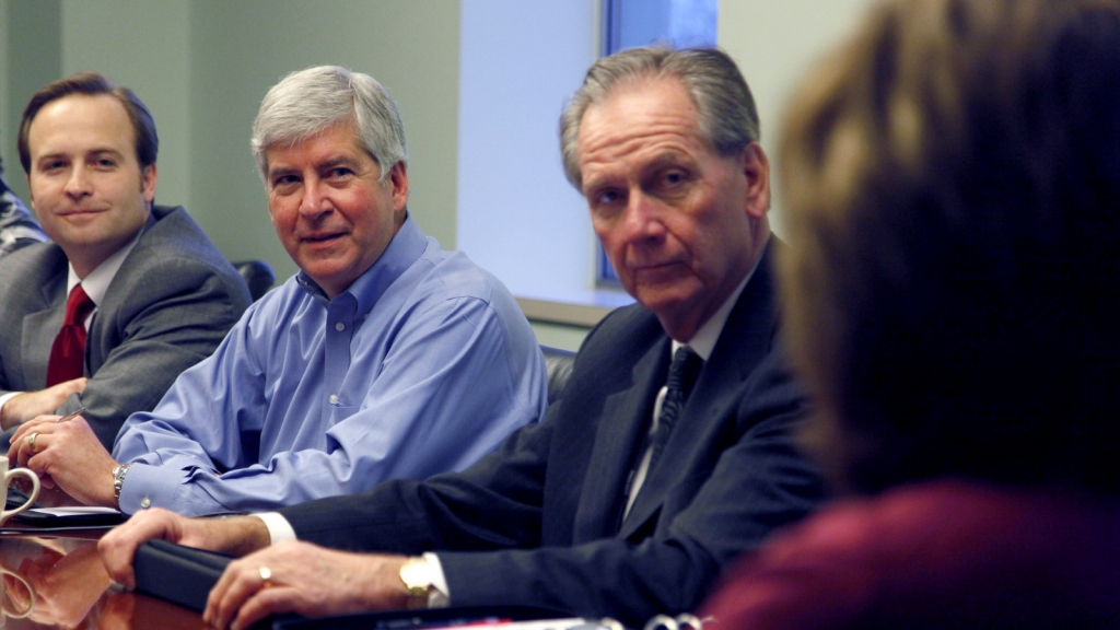 Michigan Gov. Rick Snyder center meets with senior staff to begin his first morning as governor his chief of staff Dennis Muchmore right. is married to Nestle's Michigan spokesperson Deb Muchmore. Jan. 3 2011 in Lansing Mich