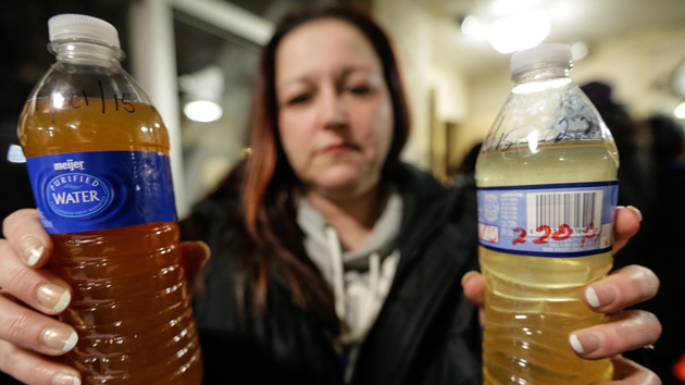 Flint resident Lee Anne Walters displays tap water samples from her home in January 2015. Ryan Garza  Detroit Free Press  ZUMA