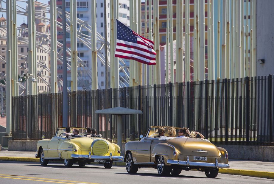 Tourists ride vintage American convertibles as they pass by the United States embassy in Havana Cuba Thursday Feb. 18 2016