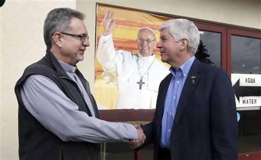 Our Lady of Guadalupe Church Deacon Omar Odette left meets with Michigan Gov. Rick Snyder Friday Feb. 5 2016 in Flint Mich. Snyder visited the church that's distributing water and filters to its predominantly Latino parishioners. (AP