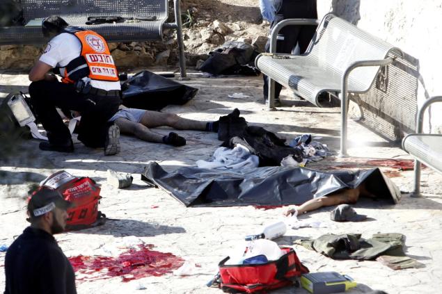 An Israeli medic inspects the body of a Palestinian at the scene of a shooting attack near the Damascus gate Jerusalem's Old City on Wednesday