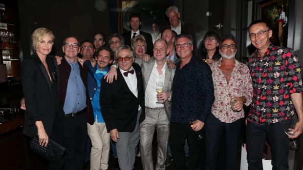 George Miller and Charlize Theron celebrate with others at a pre Oscar bash