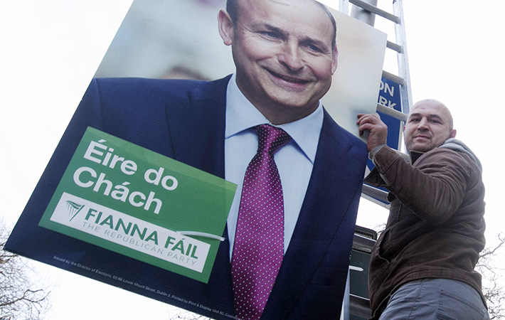 Getting an early start- Andrei Ghilan from Moldova hangs election posters for Fianna Fail outside Buswell's Hotel