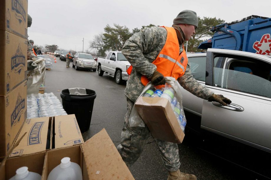 Members of the Michigan National Guard load bottled water for residents at a fire station Thursday Jan. 28 2016 in Flint Mich. The Michigan Legislature voted Thursday to direct another $28 million to address Flint's water emergency allocating money