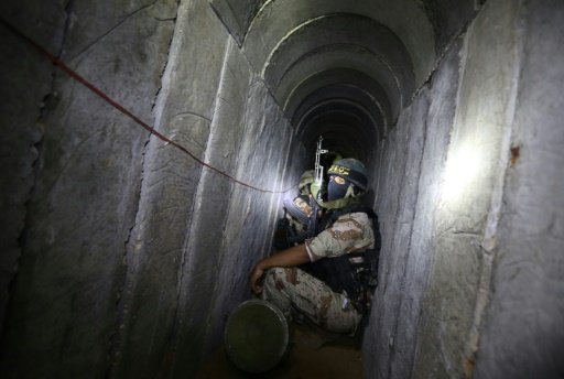 Palestinian militants from the Islamic Jihad’s armed wing the Al Quds Brigades squat in a tunnel used for storing weapons as they take part in military training in the south of the Gaza Strip