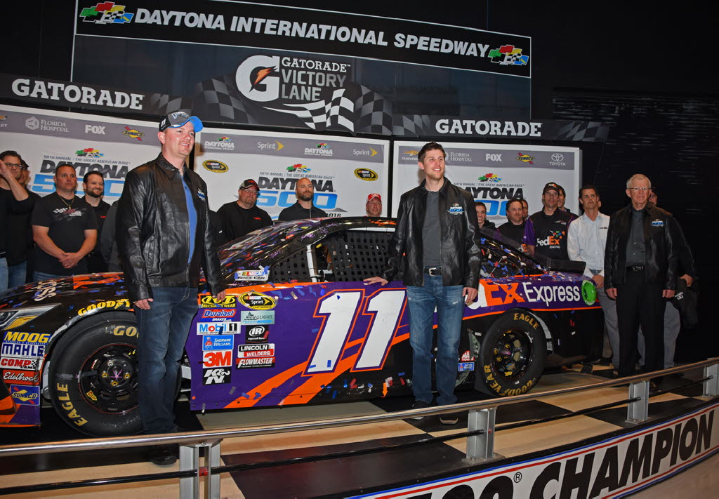 Daytona 500 winning car inducted into Daytona International Speedway's Ticket and Tours Building where it will be on display for next year. Shown with winner Denny Hamlin crew chief Mike Wheeler and team owner Joe Gibbs and full track-side team. [Jo