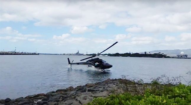 In this image taken from video provided by Shawn Winrich a helicopter crashes near Parl Harbor Hawaii on Thursday Feb. 18 2016. The private helicopter with five people aboard crashed and sunk into the water leaving a teenage passenger in critical con