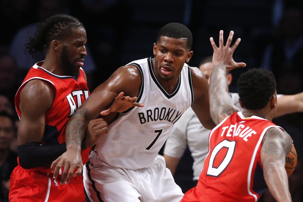 Brooklyn Nets Joe Johnson works against a double team from Atlanta Hawks De Marre Carroll left and Jeff Teague during the fourth quarter of an NBA basketball game Wednesday