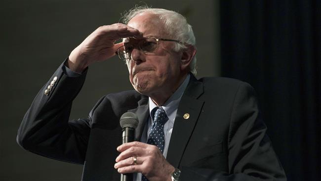 Democratic presidential candidate Senator Bernie Sanders shades his eyes to see the crowd at a forum on race and economic opportunity at Patrick Henry High School