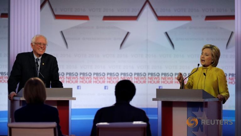 Hillary Clinton speaks as Bernie Sanders listens. REUTERS  Jim Young